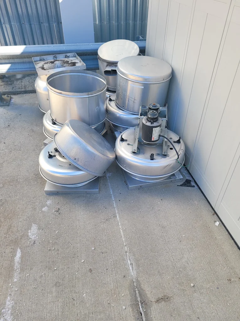 Rooftop exhaust fans, blower housings and ductwork staged for removal and metal recycling