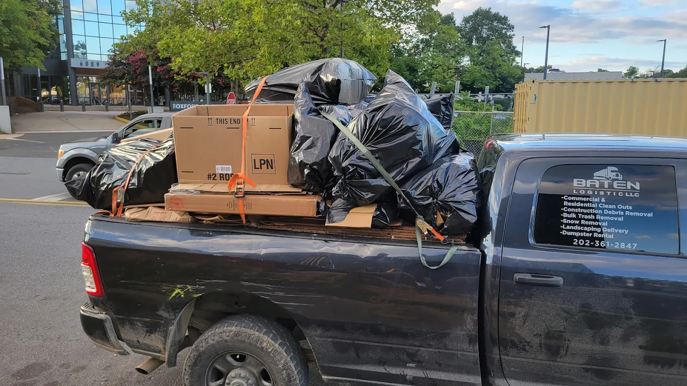 Baten Logistic pickup truck strapped and loaded with boxes and bagged debris at a commercial property