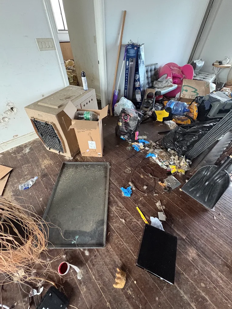 Trashed room with debris across the floor before a Baten Hauling post-tenant cleanout