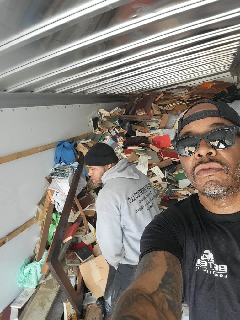 Mario Baten and crew loading a box truck full of books and furniture during a full cleanout