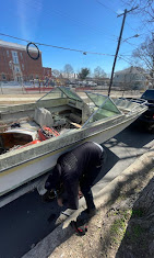 Crew removing an abandoned boat from a residential street